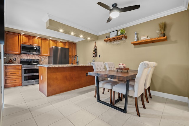 6824 68th Way, West Palm Beach, FL 33409 - kitchen featuring stainless steel appliances, brown cabinetry, decorative backsplash, crown molding, and ceiling fan