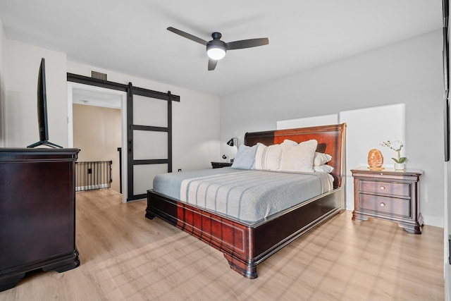 6824 68th Way, West Palm Beach, FL 33409 - bedroom featuring a barn door, light wood-style floors, and a ceiling fan