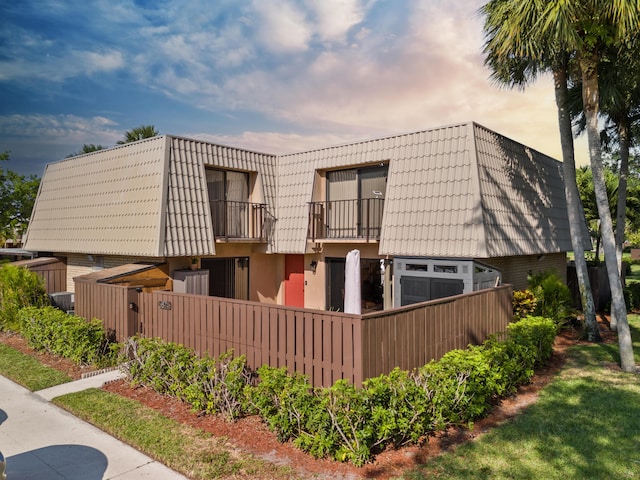 6824 68th Way, West Palm Beach, FL 33409 - view of front of home featuring mansard roof, a balcony, and stucco siding