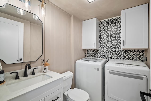 6824 68th Way, West Palm Beach, FL 33409 - bathroom featuring washer and clothes dryer, toilet, vanity, and backsplash