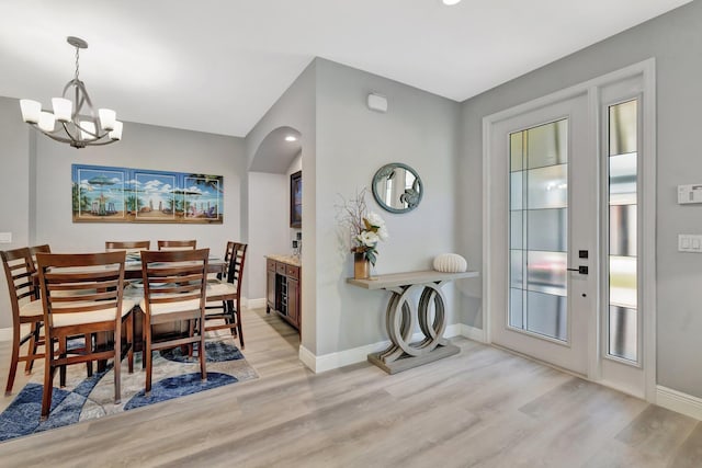 1236 SE Conference Cir, Stuart, FL 34997 - dining room with light wood-style floors, a chandelier, and arched walkways