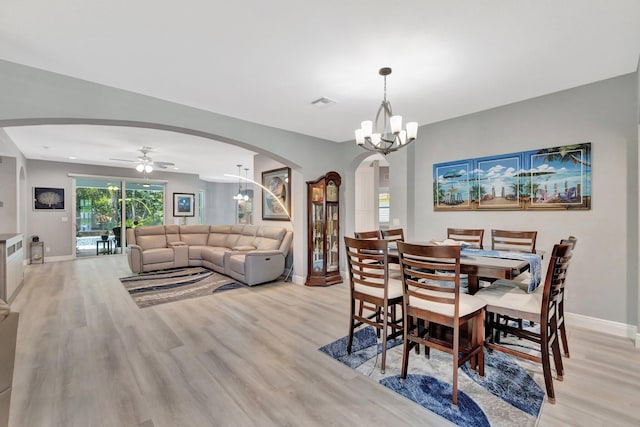 1236 SE Conference Cir, Stuart, FL 34997 - dining space with arched walkways, light wood-type flooring, a ceiling fan, and a chandelier