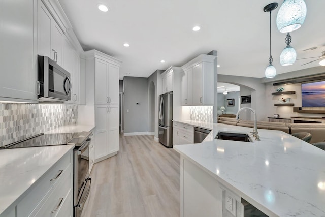 1236 SE Conference Cir, Stuart, FL 34997 - kitchen with appliances with stainless steel finishes, a ceiling fan, decorative backsplash, light wood-style flooring, and white cabinets