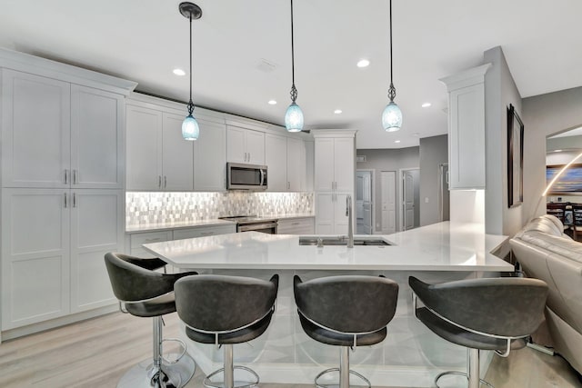 1236 SE Conference Cir, Stuart, FL 34997 - kitchen with appliances with stainless steel finishes, light countertops, tasteful backsplash, a kitchen breakfast bar, and a peninsula
