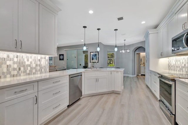1236 SE Conference Cir, Stuart, FL 34997 - kitchen featuring appliances with stainless steel finishes, light wood-style floors, backsplash, white cabinetry, and recessed lighting