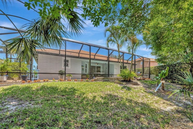 1236 SE Conference Cir, Stuart, FL 34997 - rear view of house with a ceiling fan, stucco siding, a yard, a lanai, and a tile roof