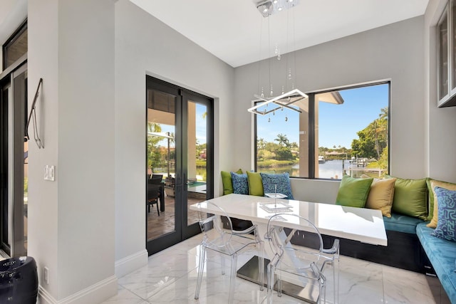 2783 Rhone Dr, Palm Beach Gardens, FL 33410 - dining area with french doors, plenty of natural light, light marble finish flooring, and a chandelier