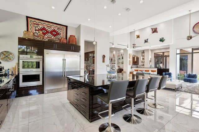 2783 Rhone Dr, Palm Beach Gardens, FL 33410 - kitchen with built in refrigerator, a high ceiling, multiple ovens, light marble finish flooring, and modern cabinets