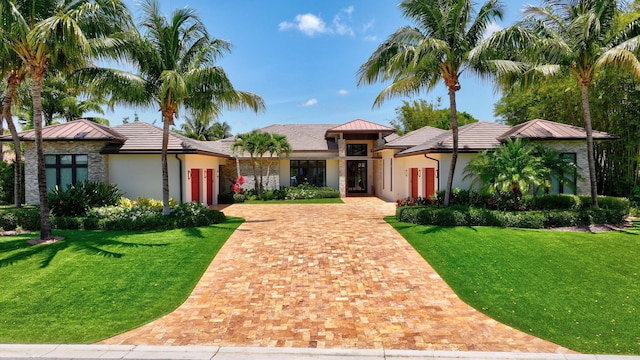 2783 Rhone Dr, Palm Beach Gardens, FL 33410 - view of front of house with an attached garage, decorative driveway, stucco siding, and a front lawn