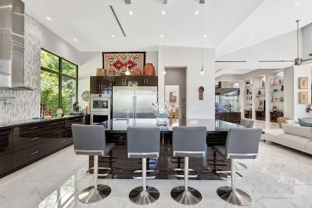 2783 Rhone Dr, Palm Beach Gardens, FL 33410 - kitchen featuring stainless steel appliances, modern cabinets, dark brown cabinetry, wall chimney range hood, and recessed lighting