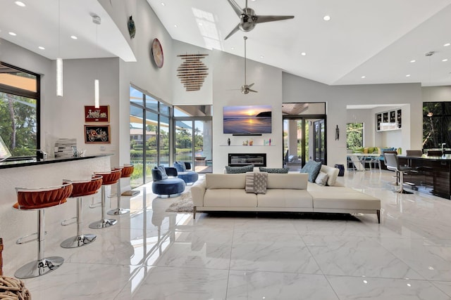 2783 Rhone Dr, Palm Beach Gardens, FL 33410 - living room featuring ceiling fan, recessed lighting, marble tiled flooring, high vaulted ceiling, and a glass covered fireplace