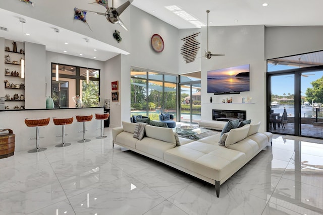 2783 Rhone Dr, Palm Beach Gardens, FL 33410 - living room with light marble finish flooring, a ceiling fan, a high ceiling, healthy amount of natural light, and recessed lighting