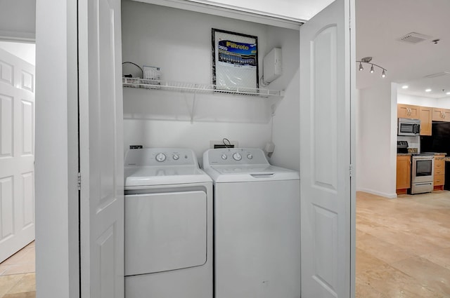laundry room featuring washer and clothes dryer, light tile patterned floors, and recessed lighting