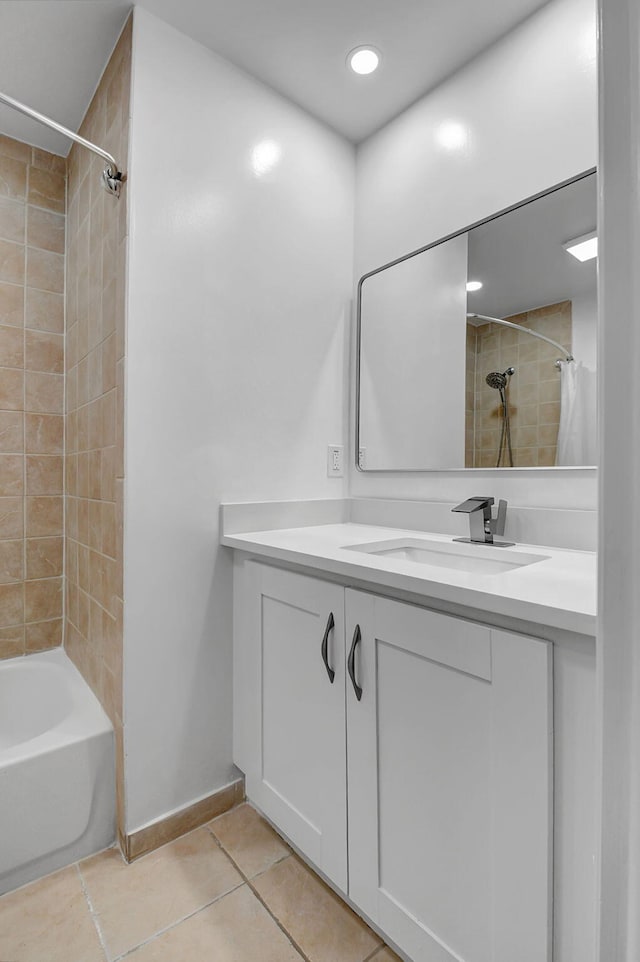 bathroom featuring tile patterned flooring, baseboards, vanity, and shower / tub combo