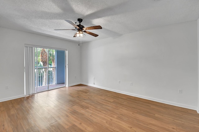 unfurnished room featuring a ceiling fan, wood finished floors, baseboards, and a textured ceiling