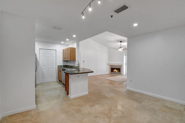kitchen featuring open floor plan, ceiling fan, a sink, appliances with stainless steel finishes, and baseboards