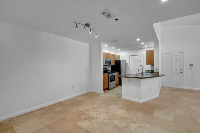 kitchen featuring appliances with stainless steel finishes, a sink, brown cabinetry, recessed lighting, and a peninsula