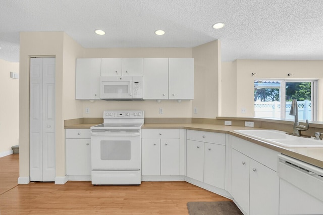 8074 Stirrup Cay Ct, Boynton Beach, FL 33436 - kitchen featuring white appliances, a sink, a textured ceiling, light wood-style flooring, and light countertops