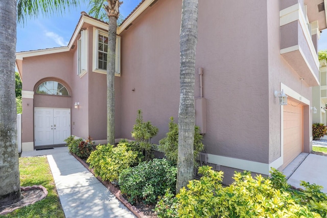 8074 Stirrup Cay Ct, Boynton Beach, FL 33436 - view of property exterior with stucco siding, a garage, and driveway