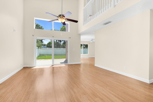 8074 Stirrup Cay Ct, Boynton Beach, FL 33436 - unfurnished living room with ceiling fan, wood finished floors, a towering ceiling, and baseboards