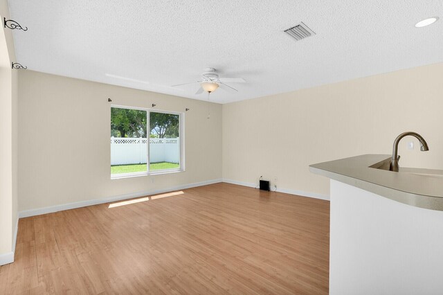 8074 Stirrup Cay Ct, Boynton Beach, FL 33436 - spare room with light wood-type flooring, a sink, a ceiling fan, baseboards, and a textured ceiling
