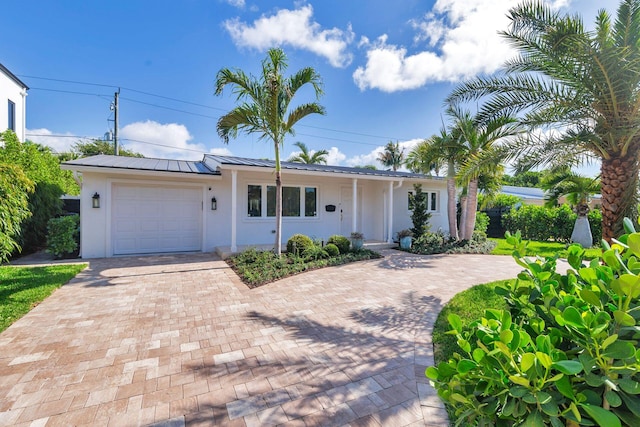 179 Arlington Rd, West Palm Beach, FL 33405 - ranch-style house with stucco siding, decorative driveway, a standing seam roof, a garage, and metal roof