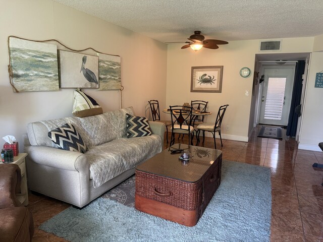2950 Sunrise Lakes Dr W Unit 101, Sunrise, FL 33322 - tiled living room with a ceiling fan, a textured ceiling, and baseboards