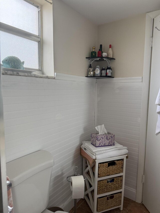 2950 Sunrise Lakes Dr W Unit 101, Sunrise, FL 33322 - bathroom featuring tile patterned floors, a wainscoted wall, toilet, and tile walls