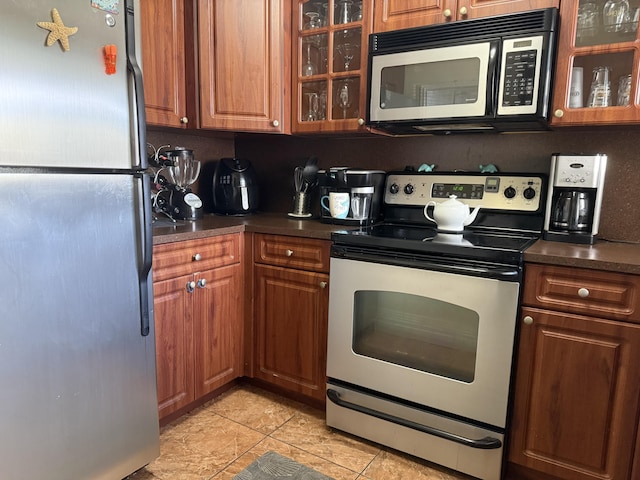 2950 Sunrise Lakes Dr W Unit 101, Sunrise, FL 33322 - kitchen with stainless steel appliances, dark countertops, and brown cabinetry