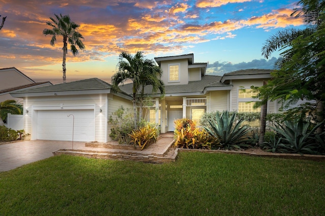 view of front of house featuring an attached garage, concrete driveway, and a front lawn