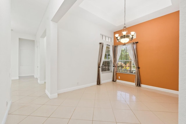 unfurnished room with a chandelier, light tile patterned flooring, and baseboards
