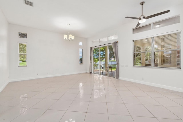 unfurnished room with a chandelier, light tile patterned floors, ceiling fan, and baseboards