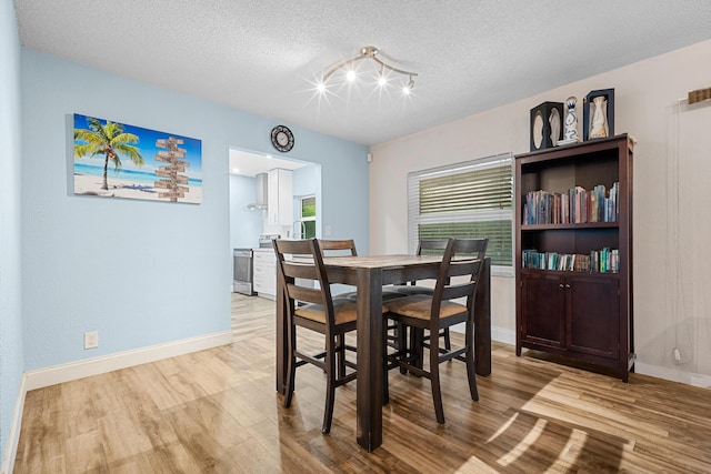 7503 NW 42nd St, Coral Springs, FL 33065 - dining space with wood finished floors, a textured ceiling, and baseboards