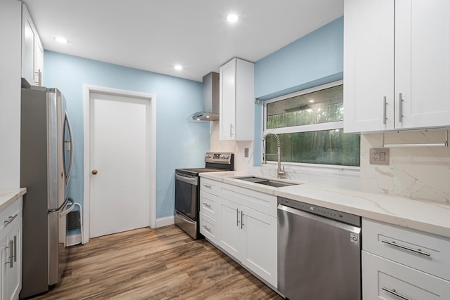 7503 NW 42nd St, Coral Springs, FL 33065 - kitchen featuring stainless steel appliances, a sink, wall chimney exhaust hood, light stone countertops, and wood finished floors