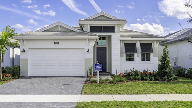 9143 SW Esule Way, Port Saint Lucie, FL 34987 - ranch-style home with driveway, an attached garage, a tile roof, stucco siding, and a front yard