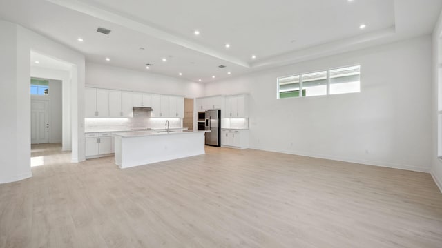 9143 SW Esule Way, Port Saint Lucie, FL 34987 - kitchen featuring stainless steel fridge, a sink, open floor plan, decorative backsplash, and a center island with sink