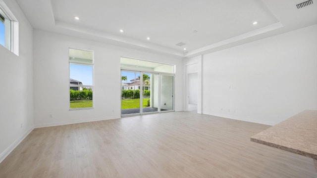 9143 SW Esule Way, Port Saint Lucie, FL 34987 - unfurnished living room featuring a raised ceiling, light wood-style floors, recessed lighting, and baseboards