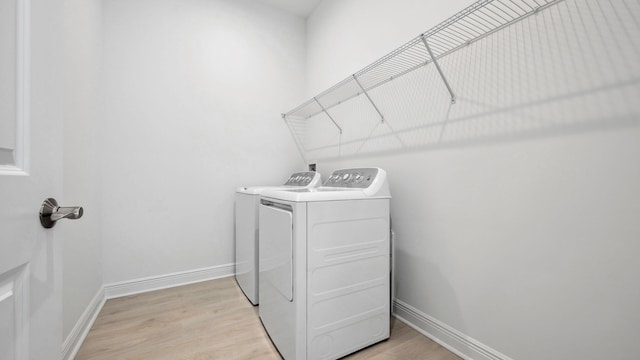 9143 SW Esule Way, Port Saint Lucie, FL 34987 - washroom featuring separate washer and dryer, light wood-type flooring, and baseboards