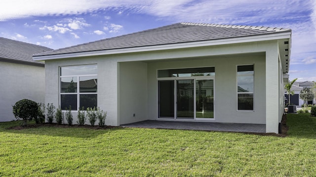 9143 SW Esule Way, Port Saint Lucie, FL 34987 - back of property with stucco siding, a lawn, a tile roof, and a patio area