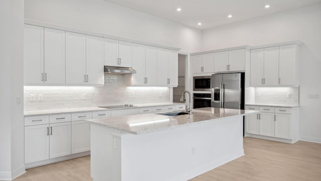 9143 SW Esule Way, Port Saint Lucie, FL 34987 - kitchen featuring stainless steel appliances, a sink, under cabinet range hood, light wood-type flooring, and white cabinets