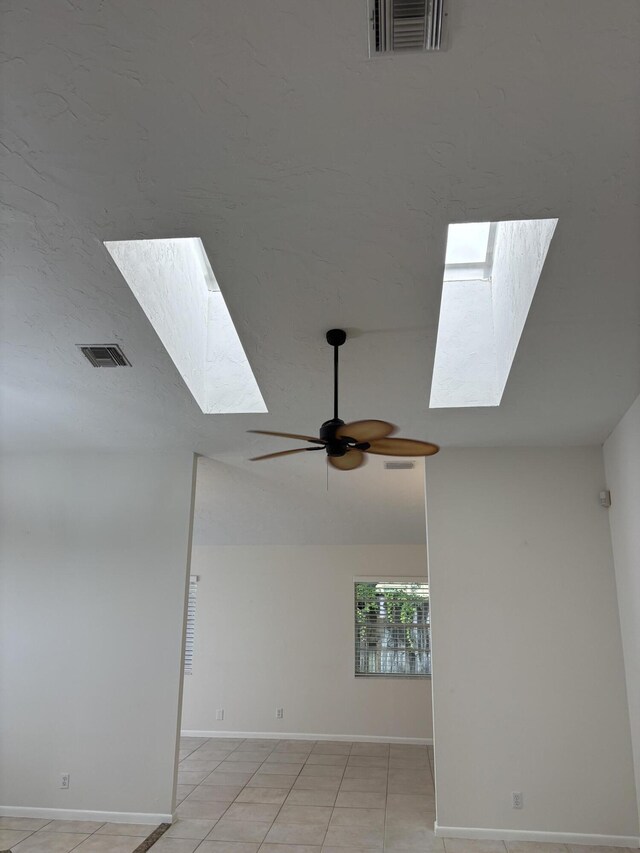 3962 Dafilee Cir, West Palm Beach, FL 33417 - unfurnished room with a skylight, a ceiling fan, baseboards, and light tile patterned floors