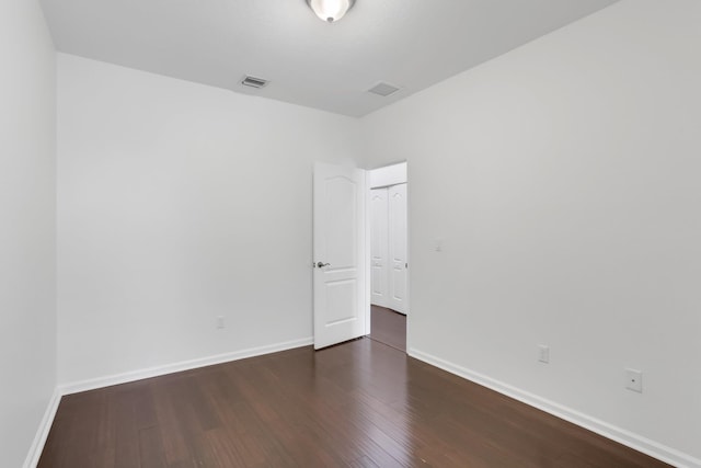 spare room with wood finished floors and baseboards