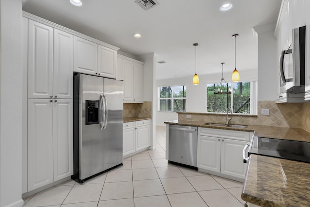 kitchen featuring stainless steel appliances, a sink, white cabinets, and recessed lighting