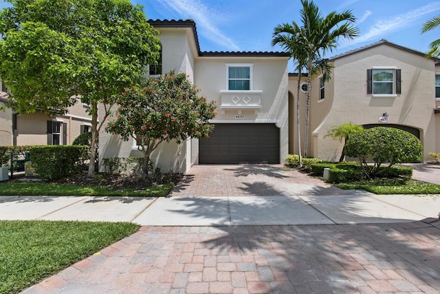 4635 Mediterranean Cir, Palm Beach Gardens, FL 33418 - view of front facade with an attached garage, decorative driveway, stucco siding, and a tile roof