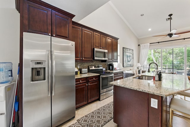 4635 Mediterranean Cir, Palm Beach Gardens, FL 33418 - kitchen featuring stainless steel appliances, a sink, tasteful backsplash, light stone countertops, and ornamental molding