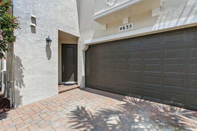 4635 Mediterranean Cir, Palm Beach Gardens, FL 33418 - property entrance with stucco siding and driveway