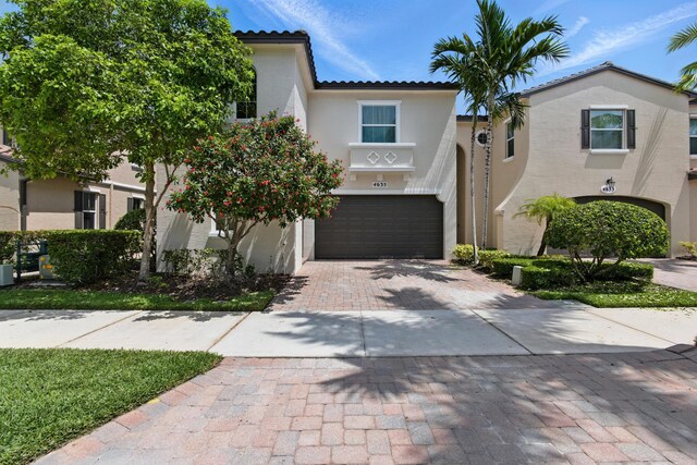 4635 Mediterranean Cir, Palm Beach Gardens, FL 33418 - view of front facade with decorative driveway, an attached garage, stucco siding, and a tile roof