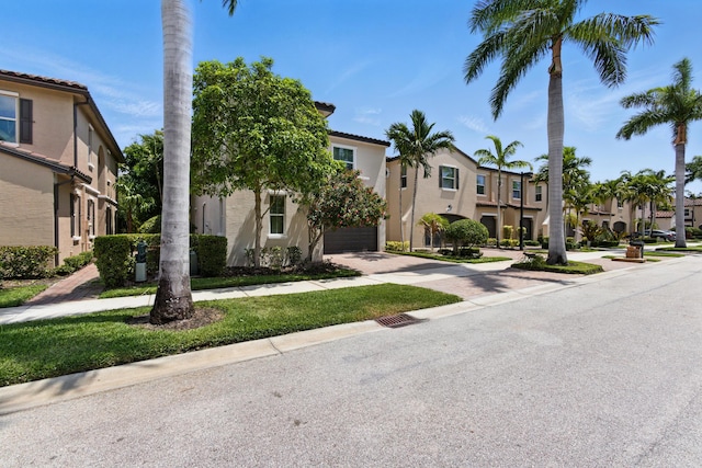 4635 Mediterranean Cir, Palm Beach Gardens, FL 33418 - view of front facade with a residential view, driveway, stucco siding, and an attached garage