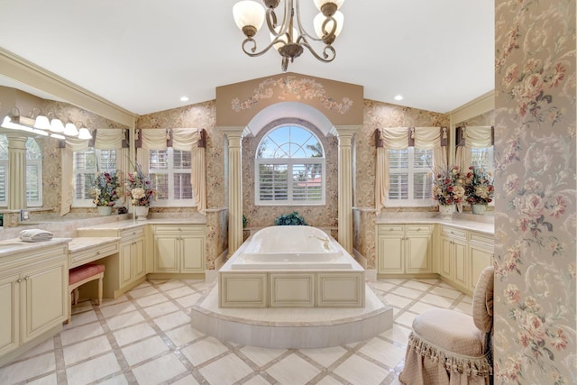 full bath with wallpapered walls, a chandelier, ornate columns, a garden tub, and vanity