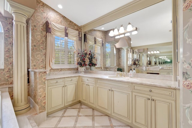 bathroom featuring ornate columns, wallpapered walls, vanity, inlaid floor details, and recessed lighting
